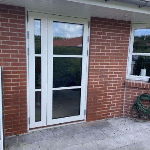 Montering af døre og vinduer i murstenshus med ny yderdør og sideparti