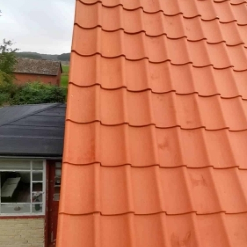 Nyt tag med røde tagsten efter udskiftning af tag på bolig