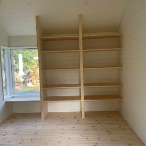 Renovering af træhus med nye indbyggede hylder og lyst trægulv