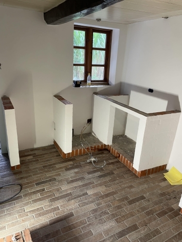 Renovering af køkken under opbygning med murede elementer og klinkegulv