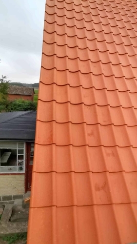 Nyt tag med røde tagsten efter udskiftning af tag på bolig