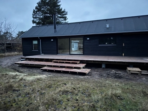 Nyt tag på sort træhus med moderne tagdækning og terrasse