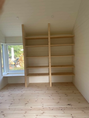 Renovering af træhus med nye indbyggede hylder og lyst trægulv