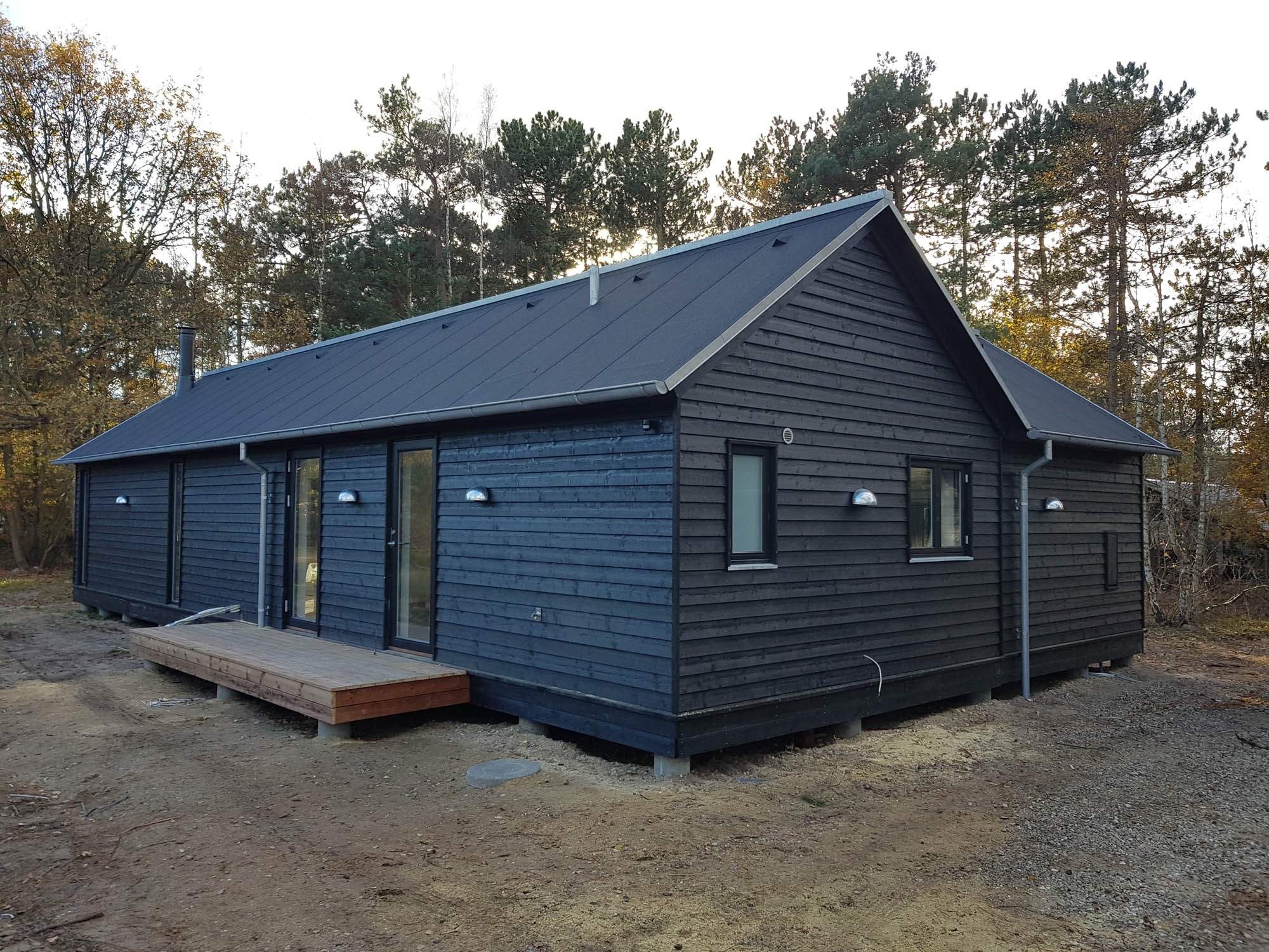 Ny tilbygning i træ med mørk facade og moderne udtryk